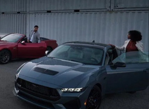 Two people standing near their 2024 Ford Mustang vehicles with the doors open near Anderson, Indiana
