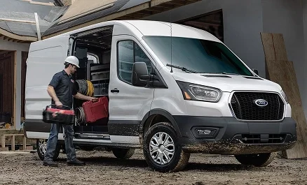 White Ford Transit work van parked beside a commercial building